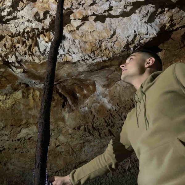 Grotte Aven Forestière Arthur devant la grosse racine d'Arbre un Arbousier